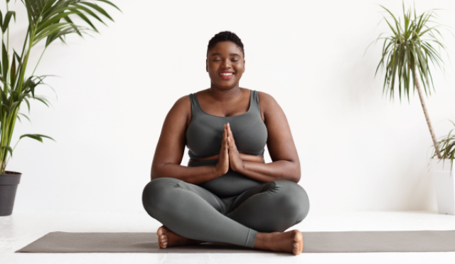 A person smiles while doing yoga
