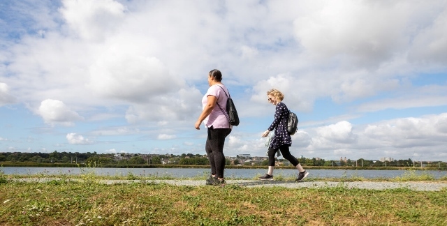 Two people walk outdoors in the Wetlands