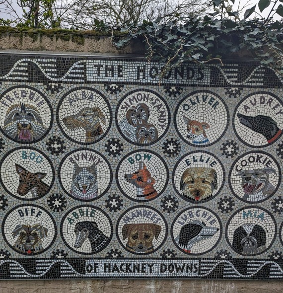 Wall of pictures of dogs done in mosaics
