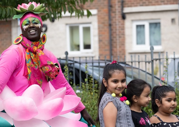 A person dressed in a carnival costume, with a lily pad headdress. 