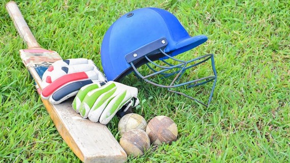 A photo of a criket bat, helmet and balls