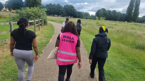 a photograph of a group of people walking down a forest path