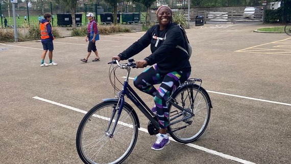 A photograph of a woman walking and smiling
