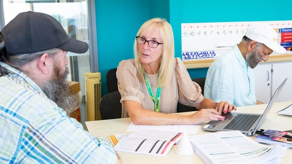 A photo of a woman talking to a man at a job fair
