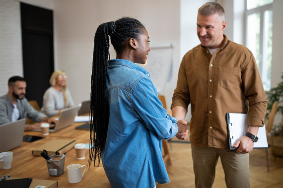 Woman with braids shaking hands with man
