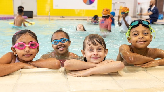 A photo of four children having a great time in the pool