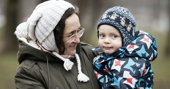 Woman in a woolly hat and coat holding a child also in a woolly hat and coat