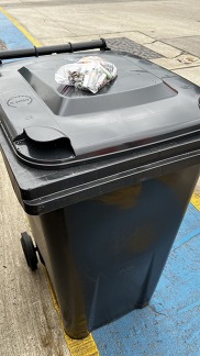 Old batteries left on top of black bin ready to be collected and recycled