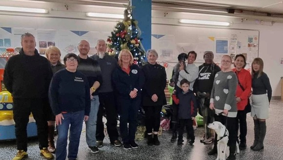 Men and women standing in front of a Christmas tree in Barrow Market