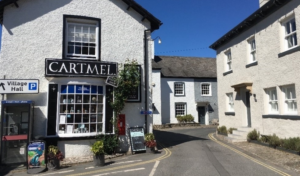 A shop in Cartmel with a road going past it into the distance
