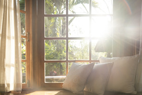 Living room with part of sofa in sunny day and white curtain