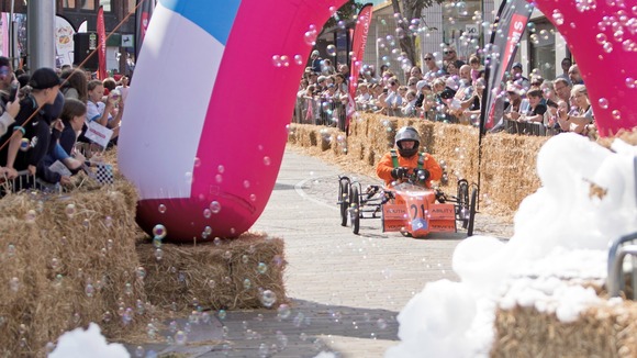 A kart going dowm the ramp at a soaabox derby