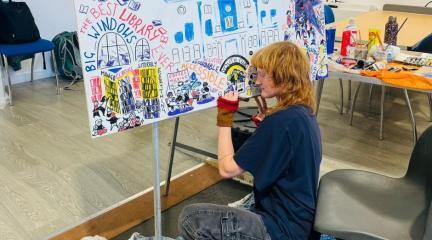 Artist Mollie Ray capturing ideas about The Coro in a comic art display