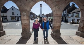 Two people standing under an arch.