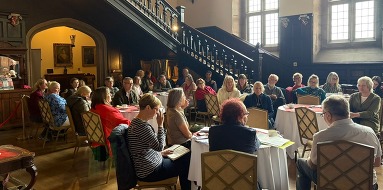 People sitting in a grand hall.