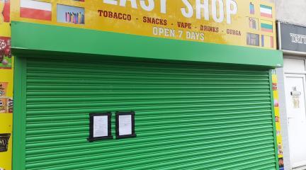 A closed shop with a green shutter