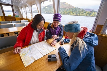 Two women sitting ata a table and looking at a map.