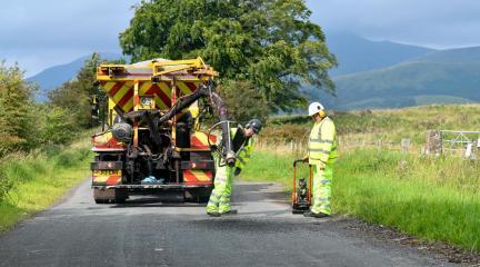 Two council workers fixing a pothole