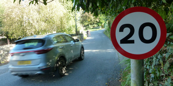 A car driving past a 20mph sign