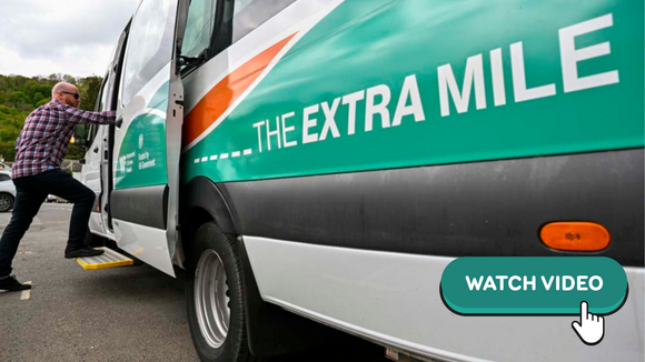 A man stepping on to a minibus