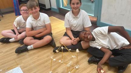 Children smiling with their pasta, STEM building creations