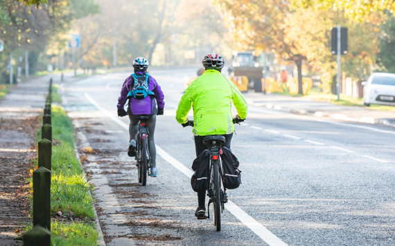 Two people cycling, photo taken from back