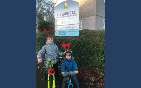 Two children with scooters decorated with tinsel