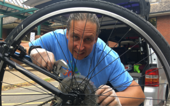 MyJourney's Dr Bike working to fix a bicycle wheel 