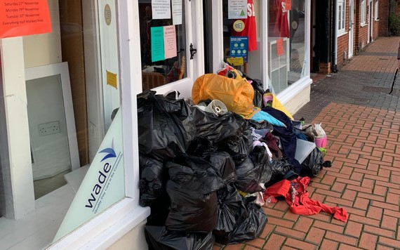 Charity shop doorway filled with black bags of clothes