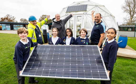 Pupils and staff at St Mary's Primary School holding up a solar panel