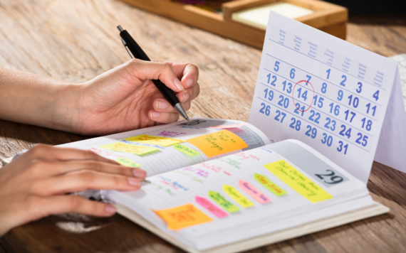 A person writing in a calendar and diary