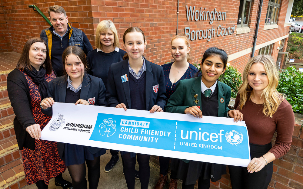 representatives from our child friendly cities delegation smile holding a UNICEF banner