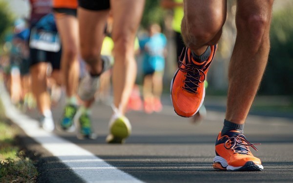 Photo showing a group of runners from the lower leg down 