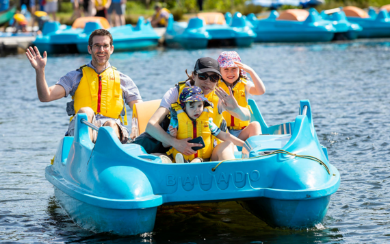 family on a pedalo waving 