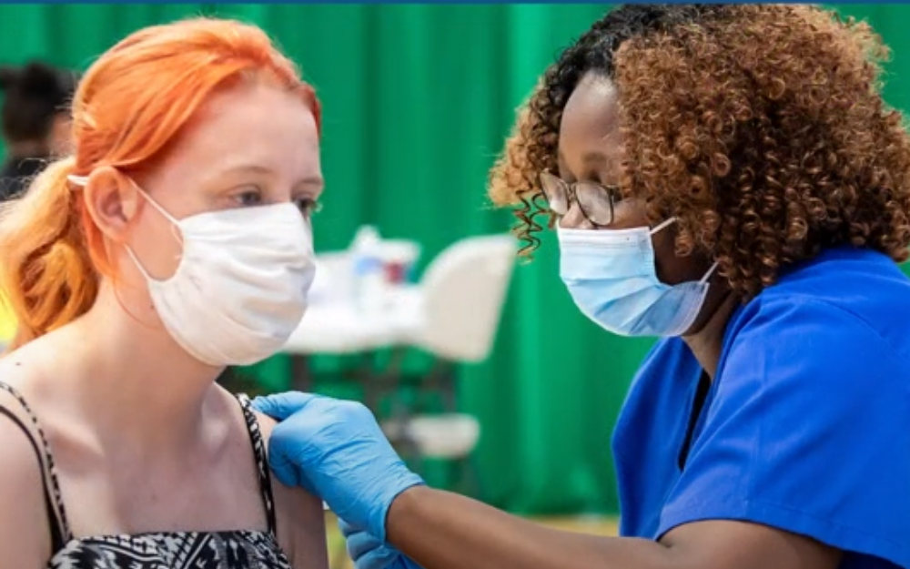 A young woman receiving her covid-19 vaccine at Bulmershe Leisure Centre