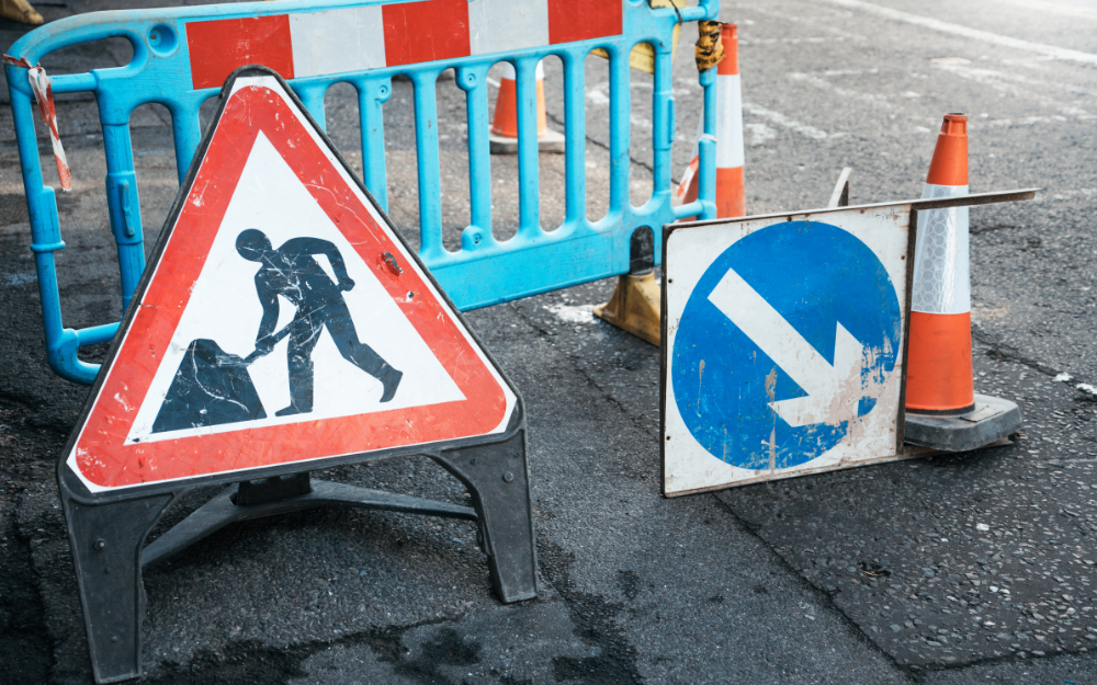 Barriers and road signs around a manhole cover during repairs