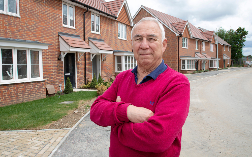 Cllr John Halsall stood in front of new housing