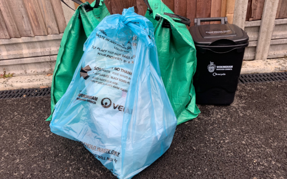 One blue general waste bag in front of two recycling bags and a food waste caddy