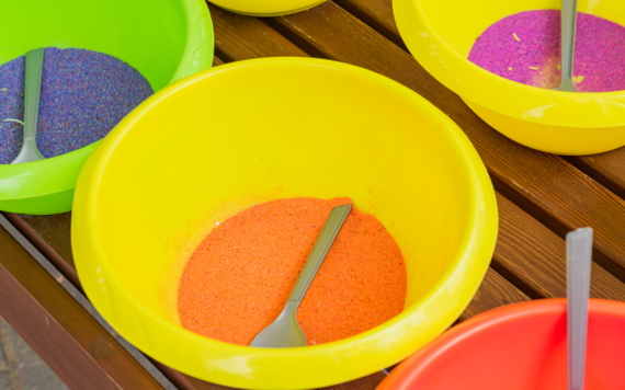 Plastic bowls full of brightly coloured crafting sand