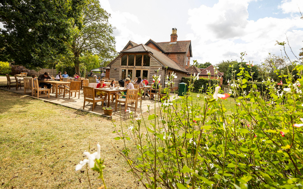 The cafe at Dinton Pastures full with people sat down in the garden