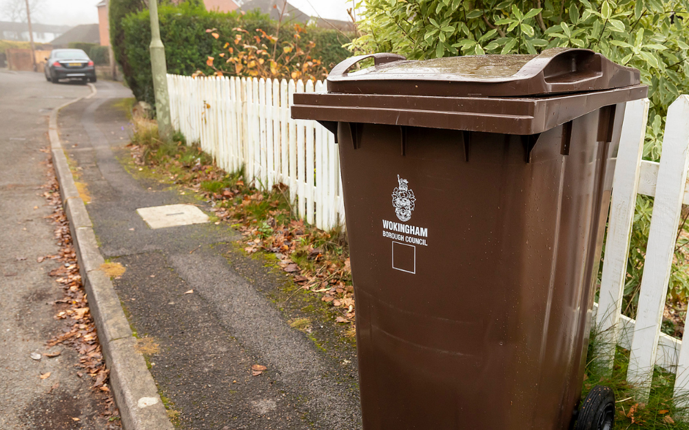 A brown garden waste wheelie bin at the kerbside