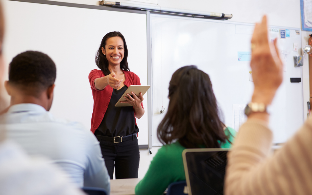 A teacher faces the classes and asks someone to respond to a question