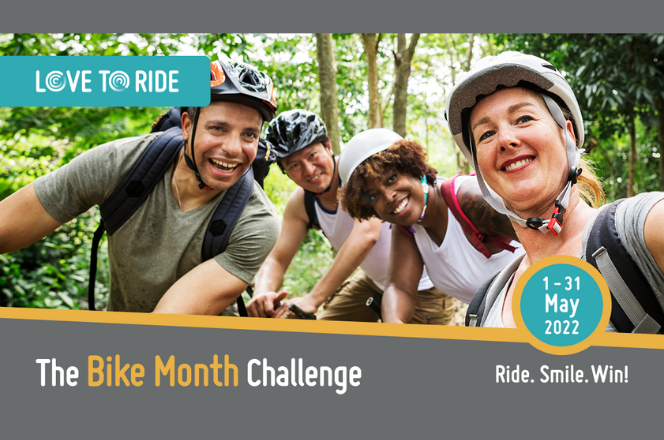 Four adults posing on bicycles in a wooded area