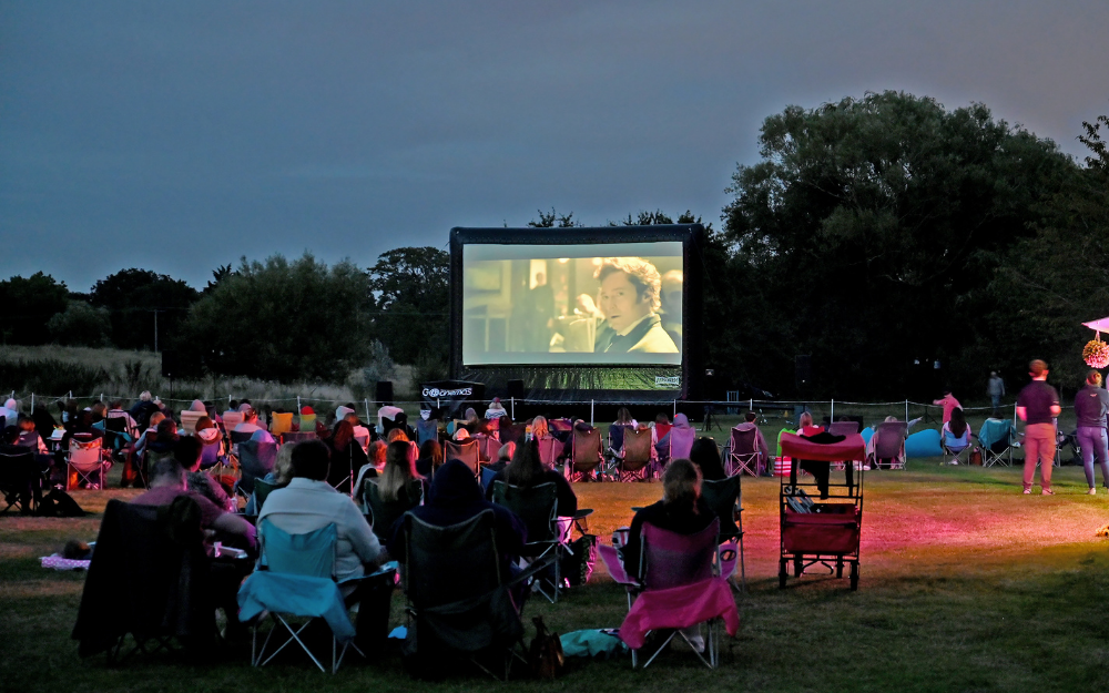 Dozens of people enjoy an outdoor cinema screening at Dinton Pastures