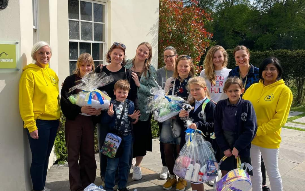 Staff from The Cowshed with items donated to local people smile to the camera