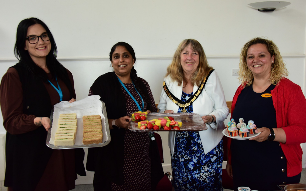 Wokingham Borough Mayor Cllr Caroline Smith smiles to the camera while holding lunch items, with three other women