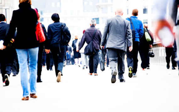 Taken from behind, several adults walking along wearing work attire