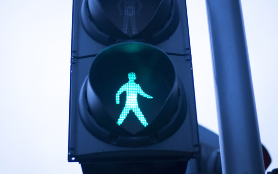 Close up of a traffic light with green man lit up