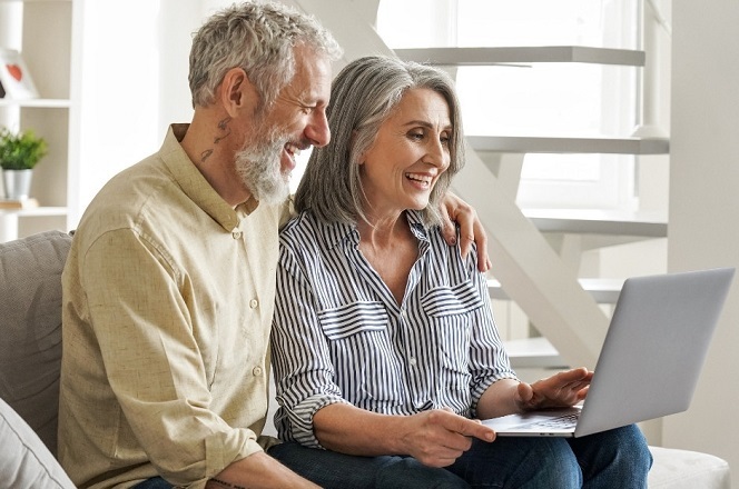 An older couple smiling at a laptop