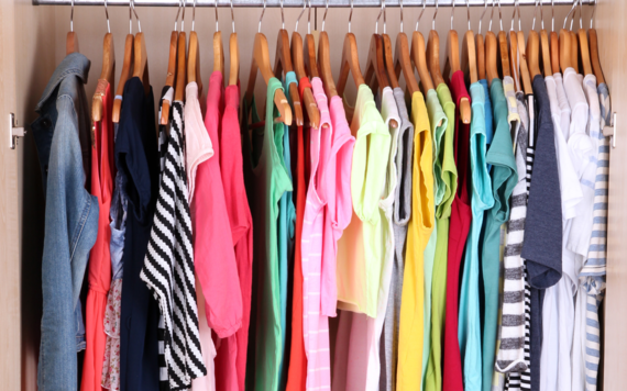 A wardrobe full of clothes in different colours